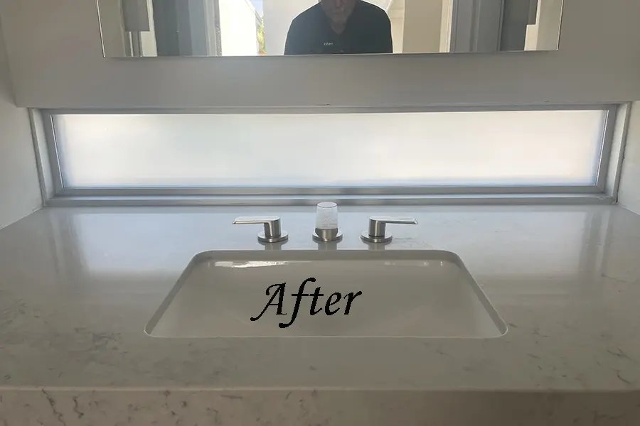 Clean bathroom sink with mirror reflection