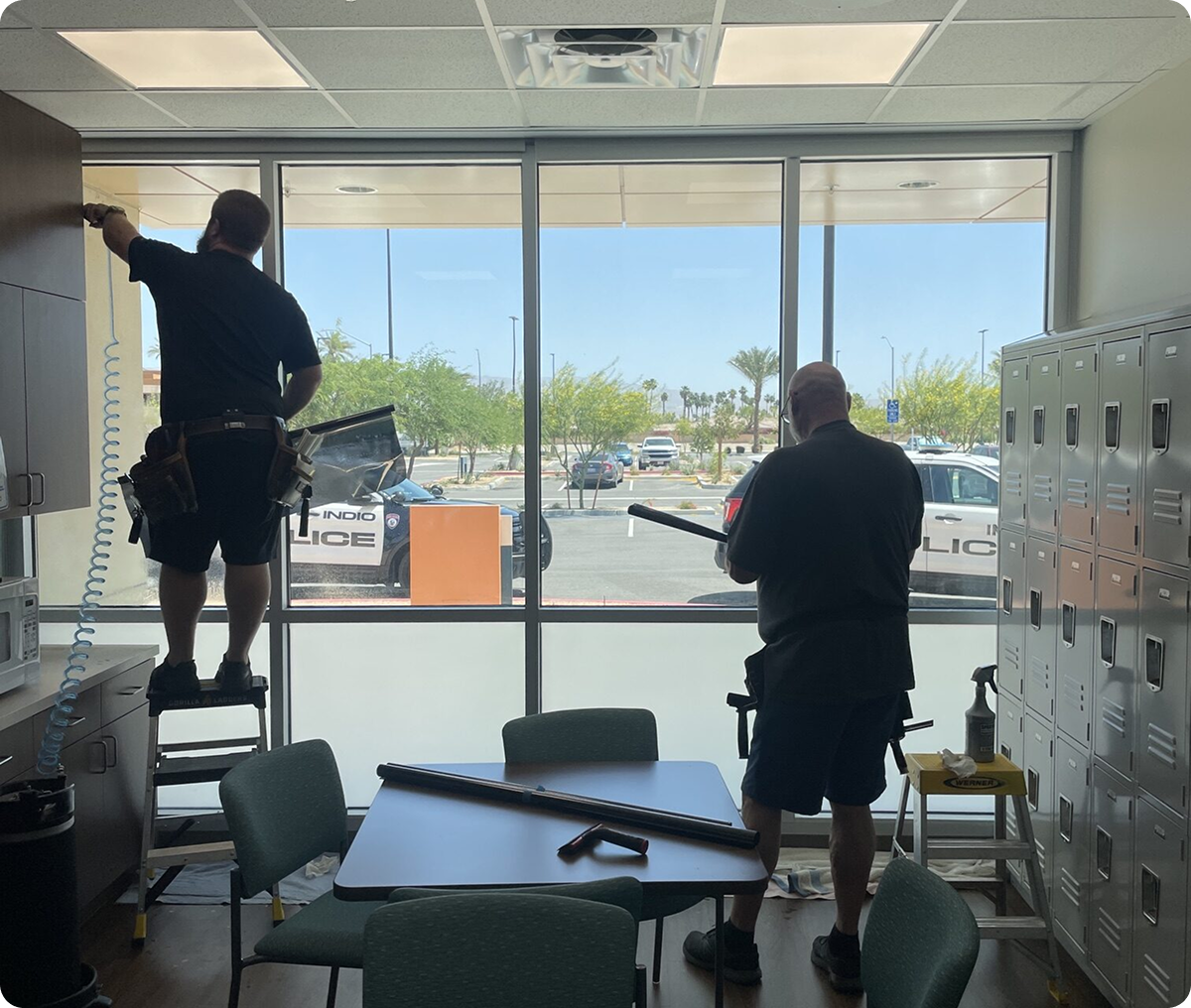 Workers applying tint to office window
