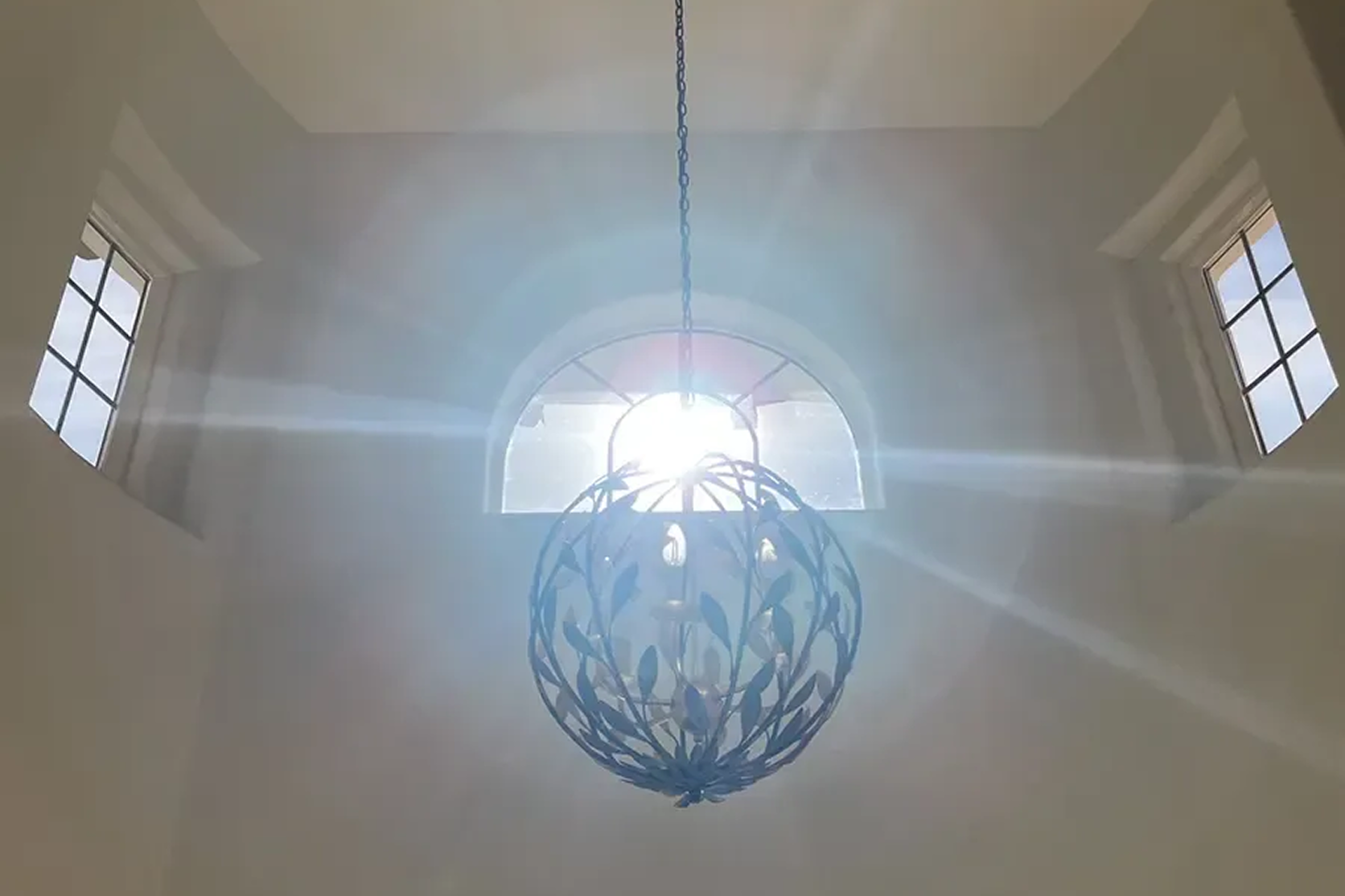 Sunlight illuminating ornate hanging light fixture